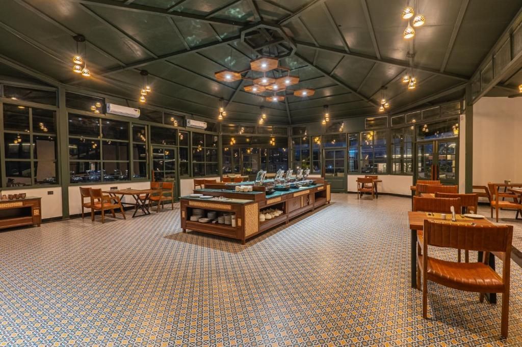 Ein Restaurant mit einer zentralen Buffetstation, verschiedenen Sitzbereichen und großen Fenstern.