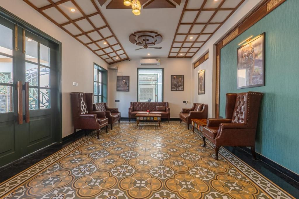 A hallway with patterned flooring, leather furniture, and framed artwork on the walls.