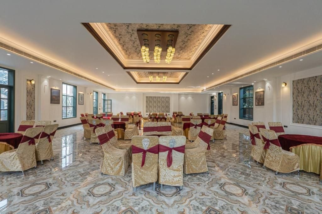 A spacious hall with rows of chairs and tables, a marble floor, and a ceiling with a light fixture.