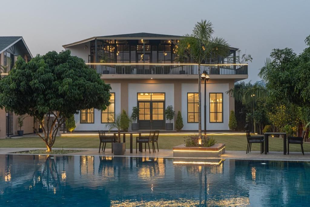 A modern two-story house with a swimming pool in front.