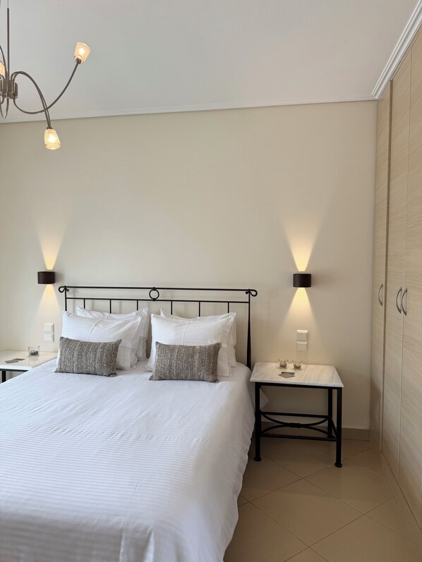 A neatly made bed with white linens and two gray pillows, flanked by black nightstands with lamps. - Apolonio Pefki Evia (Istiaia-Aidipsos)
