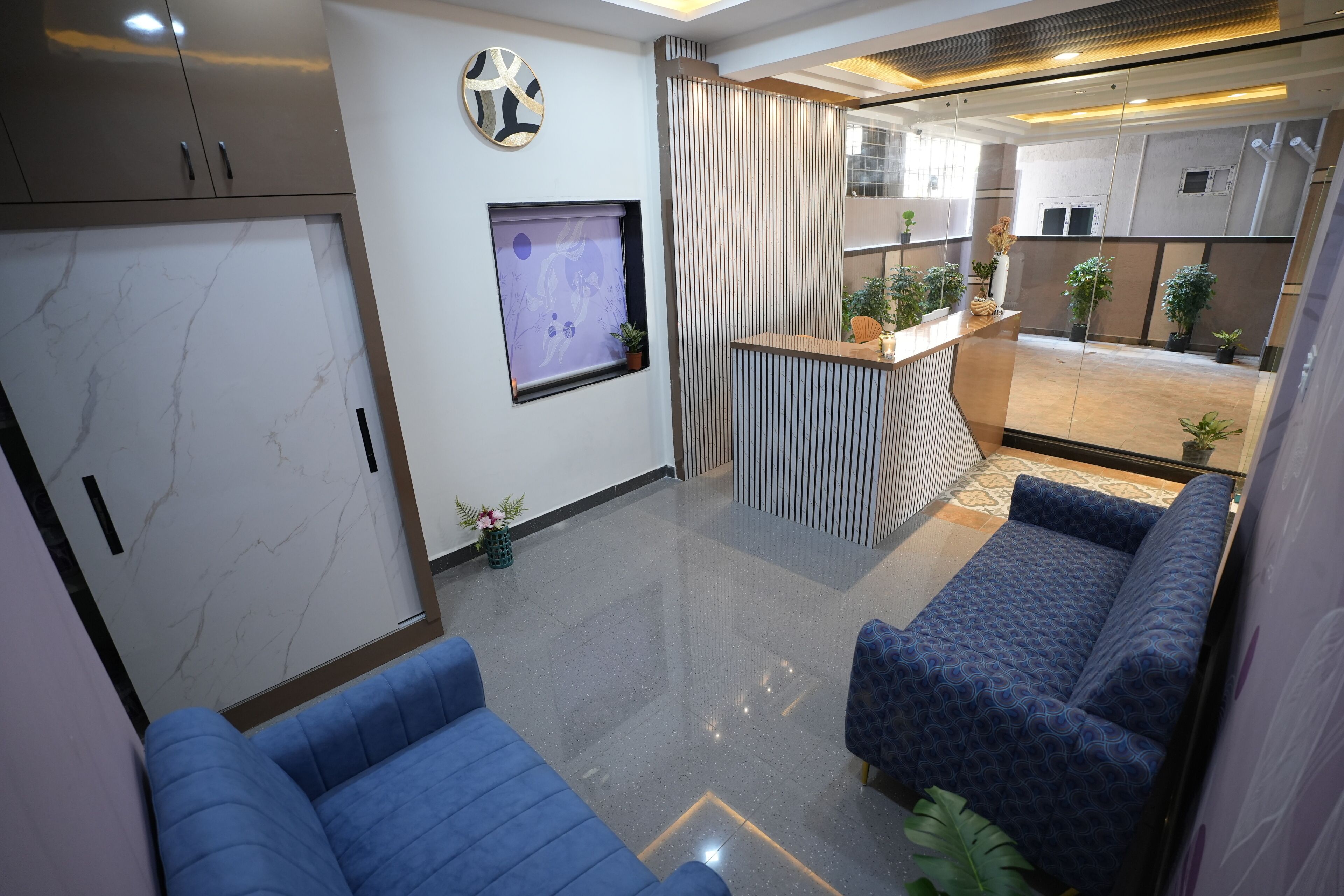 A modern living area with a sofa, a TV, and a decorative wall piece.