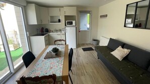 Egy kompakt, multifunkcionális lakótér, amelyben konyha, étkező és egy kanapé is található.