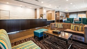 Un lobby moderno con una recepción, zona de estar y un área de comedor.