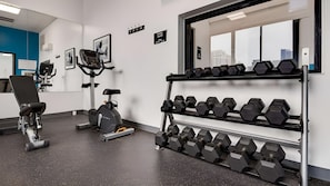 A gym with exercise equipment, including a stationary bike, a rowing machine, and a rack of dumbbells. - 3 Units | Near Chicago River | Downtown Location (Chicago)