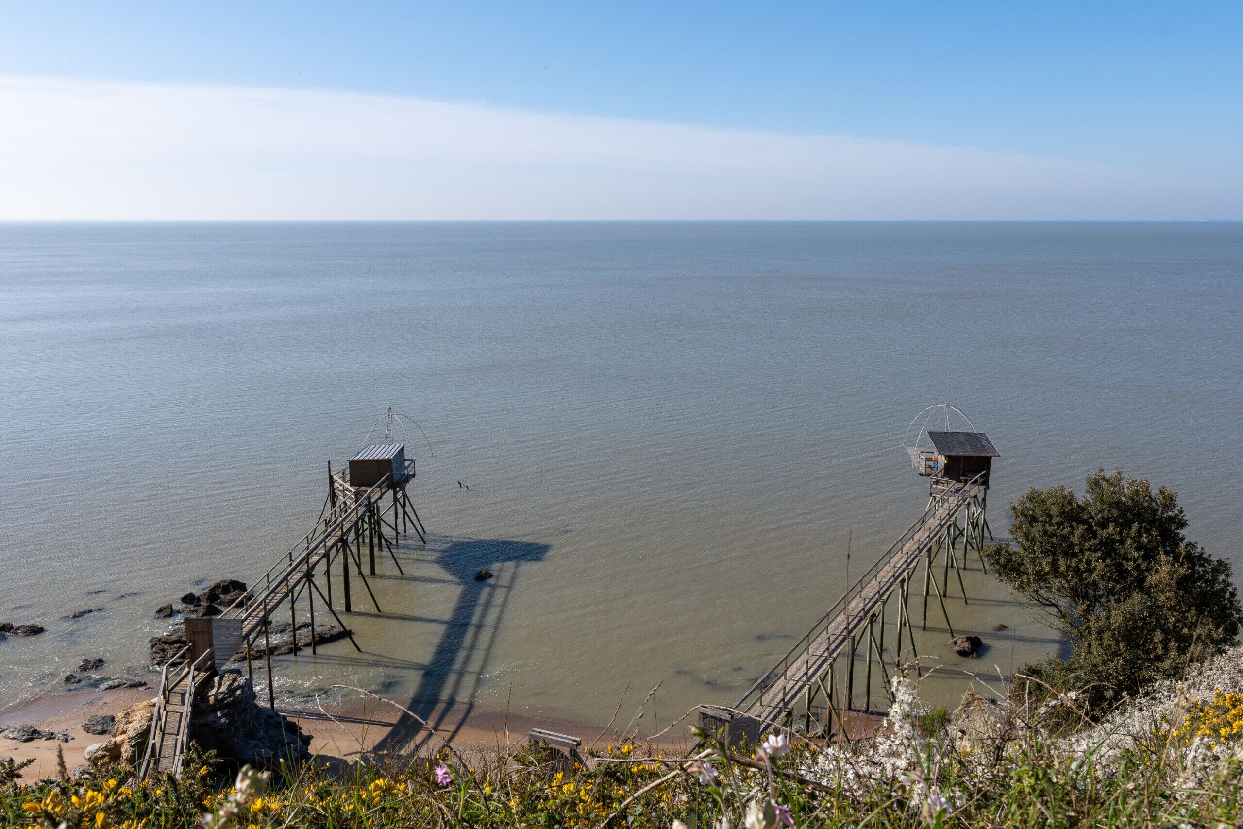 Eine Küstenansicht mit einem Pier, der sich ins Wasser erstreckt, mit zwei Aussichtstürmen.