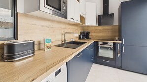 A modern kitchen with a wooden countertop, stainless steel appliances, and a built-in oven. - House for 4 adults 2 children, 30m from the sea (Noirmoutier-en-l´Ile)