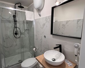 Habitación cuádruple básica | Baño | Ducha, artículos de higiene personal gratuitos y secador de pelo