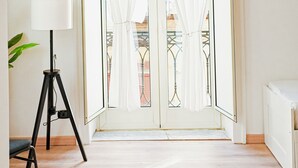 A room with a sliding glass door, a tripod lamp, and a radiator. - 174 Urban Stay (Naples)