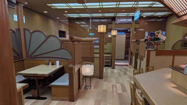 A restaurant with wooden furniture, a tiled floor, and a ceiling with skylights. - Kanonji Grand Hotel (Kanonji)