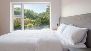 A bedroom with a large window offering a view of a forested hillside. - Yangyang Stay Y (Yangyang)