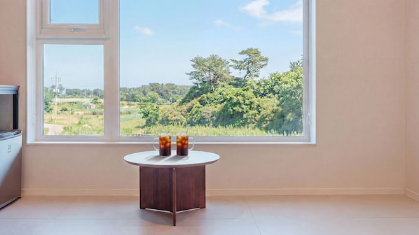 A room with a large window, a small round table with two drinks, and a TV on the left. - Yangyang Stay Y (Yangyang)