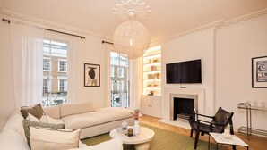 A modern living room with a sofa, coffee table, and a fireplace. - The Architect's House (London)