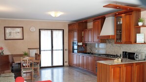 A modern kitchen with wooden cabinets, a granite countertop, and a built-in stove.