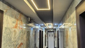 A hallway with marble walls and modern lighting fixtures. - Townhouse Oak Pawana Road Lonavala (Mawal)