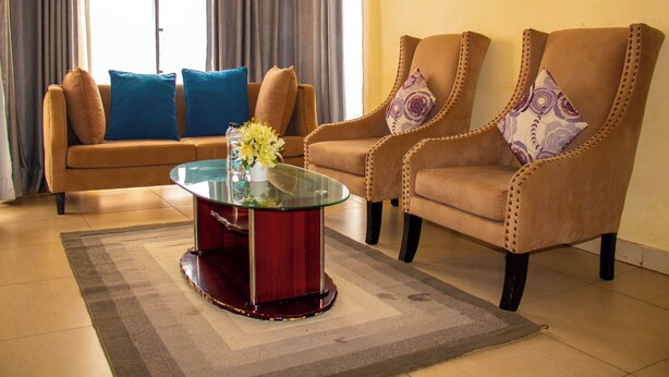 A living room with a sofa, two armchairs, a glass coffee table, and a decorative vase. - Elegant Stay near two rivers mall, Ruaka. (Ruaka)
