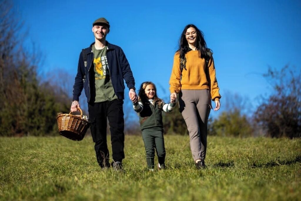 A family walking in a grassy field.