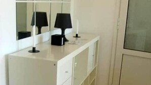 Een witte kast met lades en een spiegel erboven.