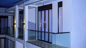 A modern building with a glass balcony and large windows.
