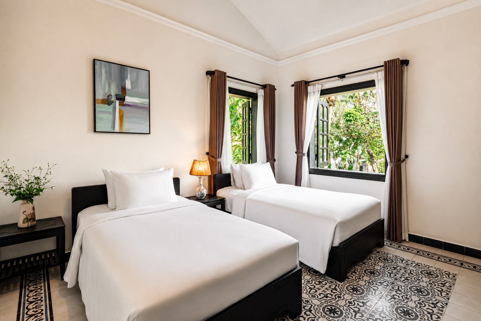 Habitación de hotel con dos camas, una mesita de noche, una lámpara, un cuadro y una ventana con cortinas.