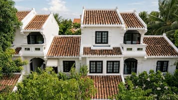 Un edificio de estilo colonial blanco con varios techos de tejas y ventanas amplias.