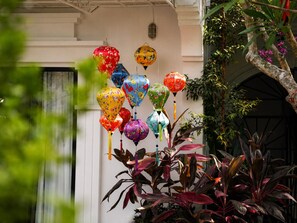 A building facade with colorful lanterns hanging in front. - MUCA Hoian Co-living & Work Retreat (Hoi An)