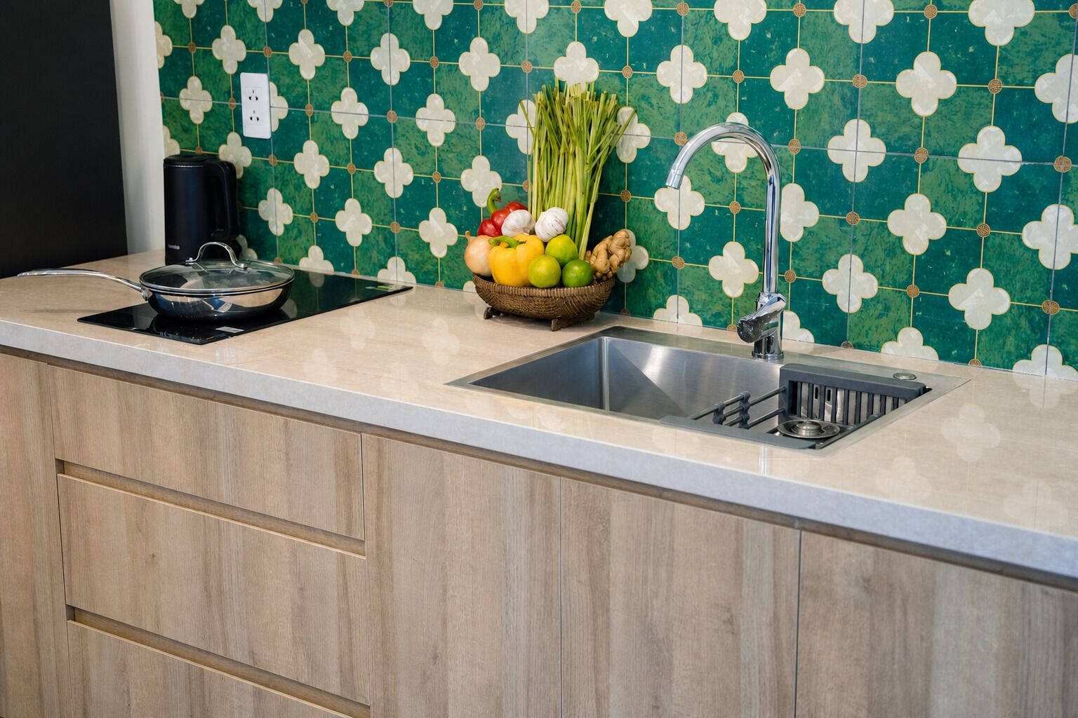 Una cocina con un lavamanos, una estufa y una encimera con una cesta de verduras.