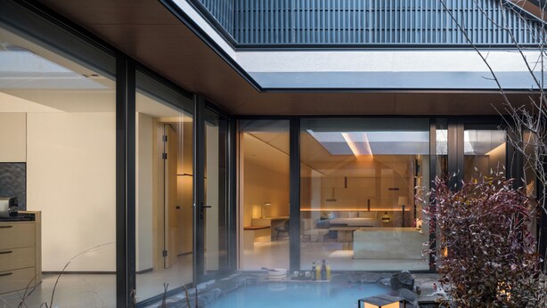 A modern building with a glass facade, a hot spring, and a lantern. - Beijing Wanli Yipiao Courtyard Hot Spring Resort (Beijing)