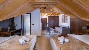 A cozy attic bedroom with two beds, wooden beams, a desk, and a chair. - Standard Room & Spa Retreat at Resort Stribor – Relax in Nature (Severin na Kupi)
