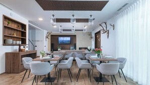 A modern dining area with a central seating arrangement, a wooden buffet, and a television screen on the wall. - Relax in Style: Comfort Room with Private Jacuzzi at Resort Stribor (Severin na Kupi)