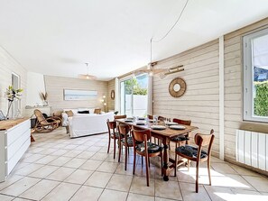 A spacious room with a dining area, a bed, and a view of the outdoors. - Ty Bottez by Interhome (Carnac)