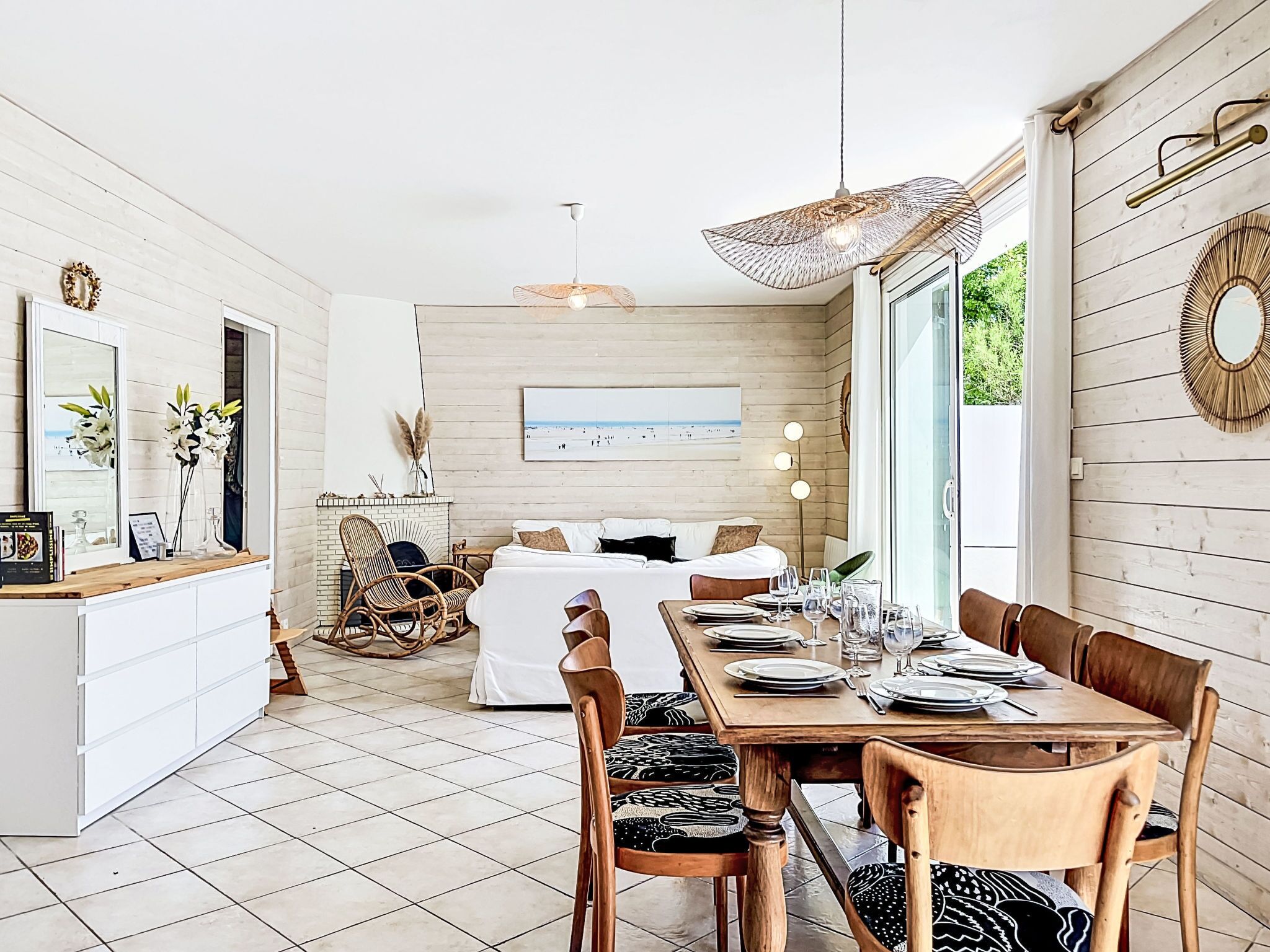 Un interior moderno con comedor, sofá y chimenea.
