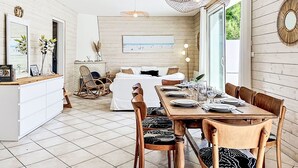 Et moderne interiør med spiseplads, sofa og pejs.