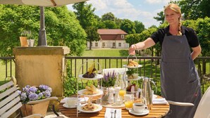 Een ontbijttafel met diverse etenswaren, een kan sinaasappelsap en een koffiepot.