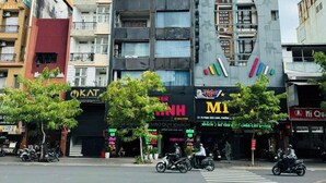 Ein mehrgeschossiges Gebäude mit verschiedenen Geschäften, darunter ein Restaurant und ein Laden mit auffälliger Beschilderung.