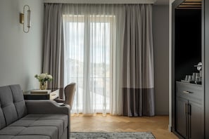 A modern living room with a sofa, a side table with a vase, and a cabinet.