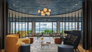 A spacious lounge with modern furniture, large windows, and a view of the outdoors. - Beau-Rivage Nyon (Nyon)