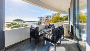 A balcony with outdoor furniture, a view of the sea, and buildings in the background. - Hill Side Suite 1 by PS (Durrës)