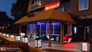 A building with a sign reading "EIKENHOF" and a covered entrance area with glass doors. - Hotel Eikenhof (Aalter)