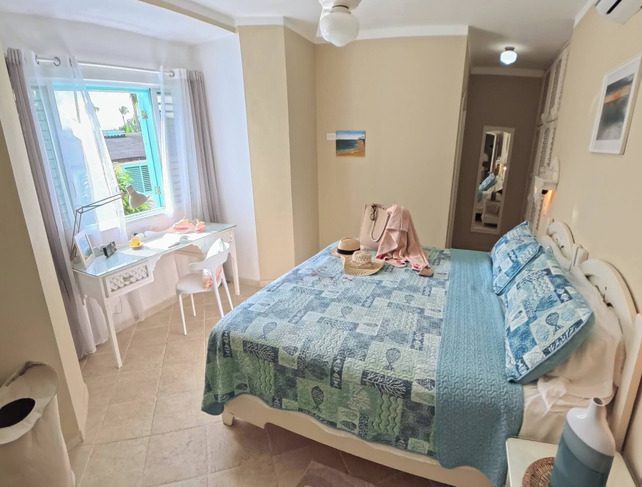 Un dormitorio con una cama, un escritorio y una silla.