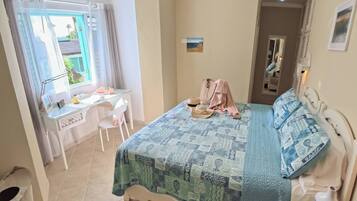 Un dormitorio con una cama, un escritorio y una silla.