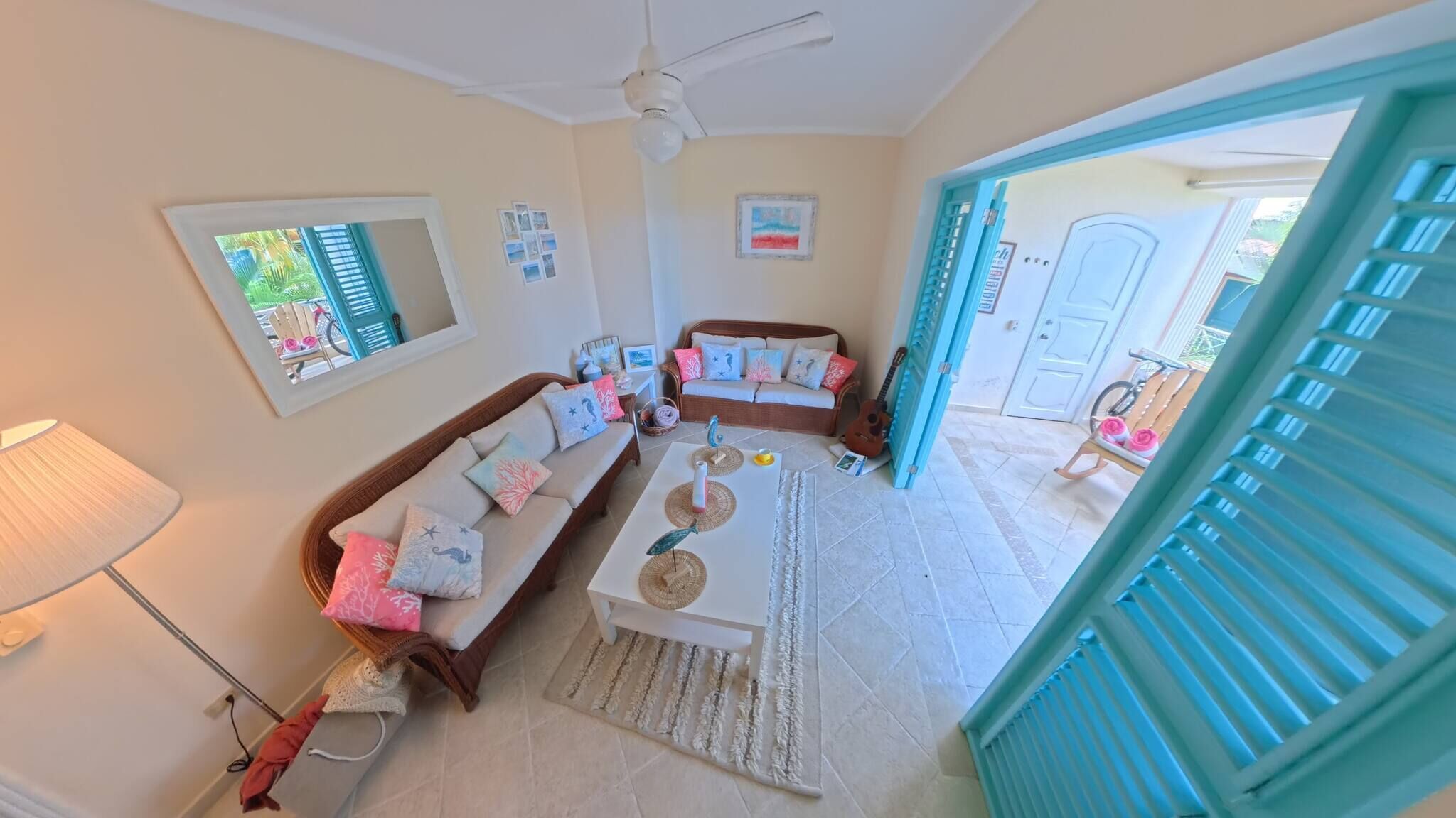 A cozy living room with a sofa, coffee table, and a ceiling fan.