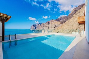 Une piscine avec vue sur la mer et les falaises.