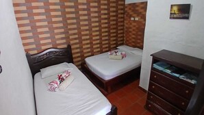 A room with two beds, a wooden dresser, and a patterned wall. - Country Cabin With Mountain Views (San Gil)