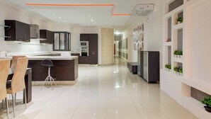 A modern kitchen with a central island, dark cabinetry, and a white countertop. - Sliema 3BDR Flat with Seaview and Jacuzzi (Tas-Sliema)