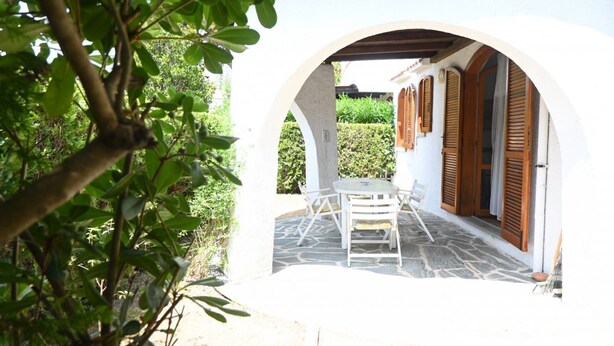 An outdoor patio with a white archway, a table and chairs, and wooden shutters. - M444 - Marcelli, comfortable four-room apartment with outdoor patio (Marcelli)