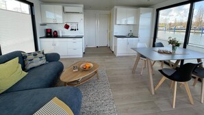 Ein stilvoller Wohnraum mit Sofa, Couchtisch, Esstisch und Küchenzeile.