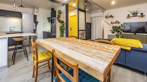 Une cuisine moderne avec une table à manger en bois, des tabourets de bar et un four encastré.