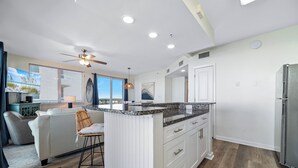 A modern kitchen with white cabinetry, a granite countertop, and a built-in island. - Beachfront-Dog Friendly-Panoramic Gulf View (Orange Beach)