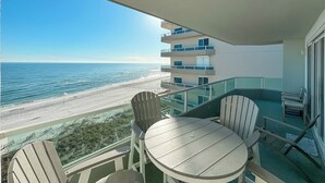 A balcony with a table and chairs overlooking a beach and ocean. - Beachfront-Dog Friendly-Panoramic Gulf View (Orange Beach)